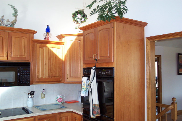 Cherry cabinetry with crown moulding and built-in appliance housing
